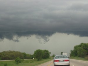 tornado forming on the horizon from the viewpoint of a car