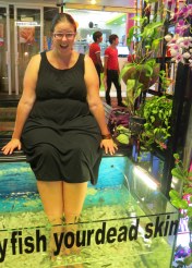 The sign on the tank reads, "Please feed our hungry fish your dead skin"