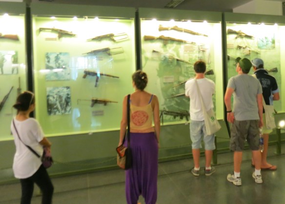 Visitors look at the guns on display